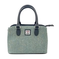 Harris Tweed Top Handle Bag Crafted from Genuine Harris Tweed with a vegan leather trim, this Top Handle Handbag is defined by its structured silhouette and generous space inside. The sturdy top handles are sized to fit comfortably in the crook of your arm, while a crossbody strap delivers easy and stylish hands-free wear. Inside this tweed handbag are two large compartments with a secure zip pocket on one side and 2 smaller open pockets on the other. The Harris Tweed bag is finished off with a Green Top Handle Bag With Leather Trim, Green Satchel Bag With Leather Trim, Green Work Bag For Fall, Green Fall Work Bag, Tweed Top Handle Shoulder Bag For Everyday, Everyday Tweed Top Handle Shoulder Bag, Everyday Tweed Shoulder Bag With Top Handle, Fall Leather Trim Shoulder Bag, Tweed Bag With Detachable Strap, Rectangular Shape