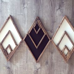 three framed pictures are hanging on a wooden wall, one is black and the other is white