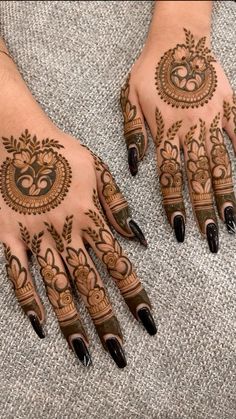 two hands with henna tattoos on them and one hand is decorated with an intricate design