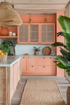 an orange kitchen with wicker baskets hanging from the ceiling and wooden cabinets, along with a rug on the floor