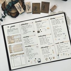 an open planner with stamps on it next to some flowers and other things in the background