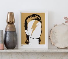 an art print of a man's head on a shelf next to vases