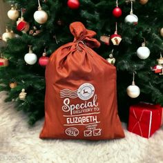 a red bag sitting next to a christmas tree