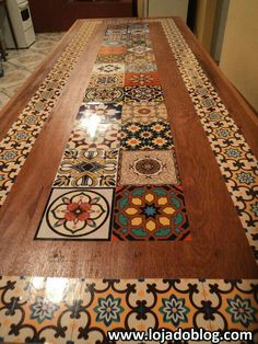 a wooden table topped with lots of different colored tile designs on it's sides