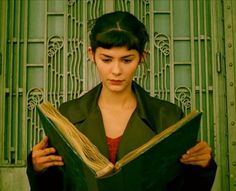 a woman is holding an open book in front of her face