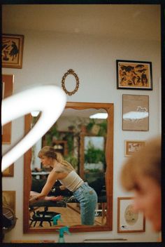 a woman standing in front of a mirror