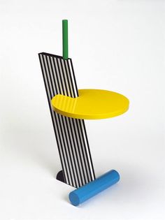 a yellow and black table with a blue base on it's side, next to a green pole