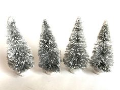 small silver christmas trees lined up on a white surface