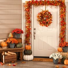 a front porch decorated for fall with pumpkins, mumlocks and other autumn decorations