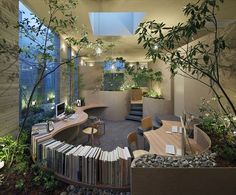 an office with lots of books and plants in the center, surrounded by stone walls