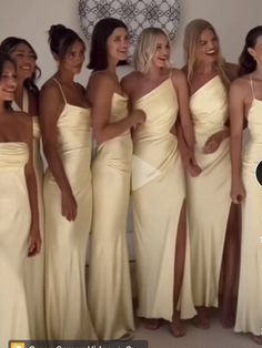 a group of women standing next to each other in white dresses and one has her hand on her hip