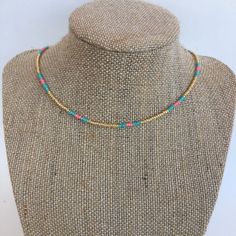 "Gold seed beads in between turquoise and salmon seed beads on a wire strand with a silver tone lobster clasp and 2\" extender" Adjustable Turquoise Necklaces With Gold Beads, Adjustable Turquoise Necklace With Gold Beads, Turquoise Heishi Beads Jewelry With Beaded Chain, Adjustable Beaded Turquoise Necklace, Adjustable Gold Turquoise Necklace With Colorful Beads, Adjustable Turquoise Beaded Chain Necklace, Adjustable Turquoise Beaded Necklace With Tiny Beads, Adjustable Gold Turquoise Beaded Necklace, Adjustable Turquoise Beaded Necklaces