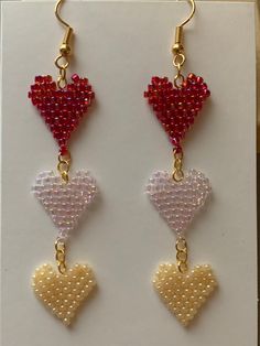 Valentine's theme heart earrings are a fun and playful way of getting in the Valentines spirit! Hand beaded red, pink and pearl hearts dangle one after another in a fun festive design you won't get anywhere else! Heart Beads Drop Earrings For Gift, Cheap Beaded Earrings With Heart Beads For Valentine's Day, Cute Heart Beads Dangle Jewelry, Valentine's Day Jewelry With Dangling Beads As Gift, Valentine's Day Gift Jewelry With Dangling Beads, Cute Heart Beaded Drop Earrings, Heart Beads Earrings For Mother's Day Gift, White Dangle Heart Earrings For Valentine's Day, Valentine's Day Jewelry Gift With Dangling Beads