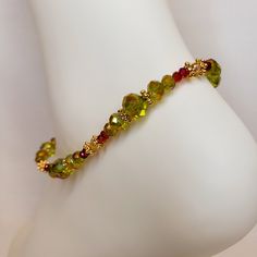 This anklet is featuring Czech crystal iridescent green round beads, vibrant magenta crystal beads with 14 kt gold plated accent beads. It is  the perfect summer accessory. Crafted entirely by hand with the highest quality materials and labor, it offers a minimalist style and natural feel. Thanks to its stretchy design, there are no sizing concerns, ensuring a comfortable fit for everyone. This anklet is an ideal gift for your best friend, bridesmaids, birthdays, or graduations, making any occasion unforgettable. Each order is beautifully packaged in an elegant box, ready for gifting. Perfect for everyday wear and any occasion, this anklet is the quintessential piece of summer jewelry. Elegant Green Anklet For Gifts, Elegant Green Anklets For Gift, Green Beaded Anklets With Round Beads, Magenta Crystal, Anklets For Women, Beaded Ankle Bracelets, Beaded Ankle, Anklets Boho, Beach Anklets