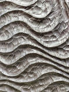 an abstract sculpture made out of paper with wavy lines