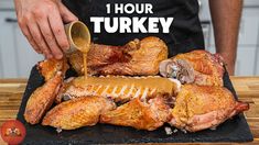 a man is pouring sauce on a turkey that has been cut into pieces and placed on a black platter