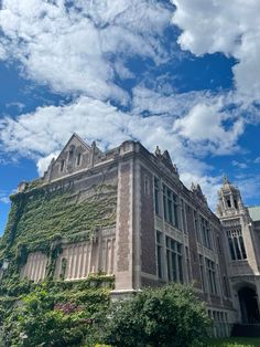 an old building with ivy growing on it's side and the sky in the background