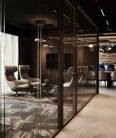 an office with glass walls and chairs