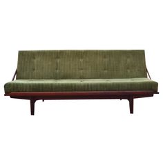 a green couch sitting on top of a wooden frame