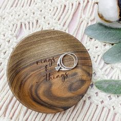 a wooden ring box with the words rings and things engraved on it next to flowers