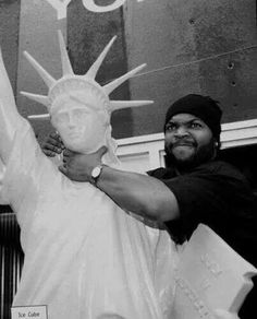 a man standing next to a statue of liberty