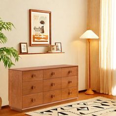 a wooden dresser sitting next to a lamp on top of a hard wood floor in a living room