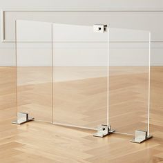 three glass dividers sitting on top of a hard wood floor