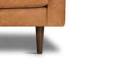 a tan leather chair with wooden legs and arm rests on an isolated white background,