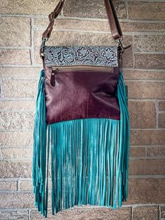 With sprinkles of turquoise frills complementing the earthy brown, this bag will look perfect with boho outfits. Cowhide will vary. No two bags will be the same. You may or may not receive the image example shown. Please contact us if you're looking for a specific cowhide. Materials LEATHER + HAIRON LEATHER Item Width 9.5 Item Height 9 Shoulder 22 Turquoise Bags For Festivals, Brown Bohemian Satchel With Fringe, Bohemian Turquoise Bags For Festival, Blue Bohemian Leather Bag, Bohemian Blue Leather Bag, Brown Bohemian Fringe Satchel, Bohemian Brown Fringe Satchel, Bohemian Brown Satchel With Removable Pouch, Bohemian Turquoise Tote Bag