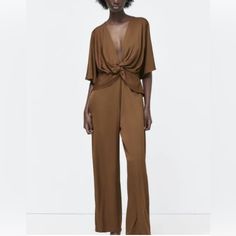 This Zara Jumpsuit Is A Must-Have For Any Fashion-Forward Woman. The Striking Plunging Neckline And Wide-Leg Design Make It Perfect For Any Occasion, From A Party To A Casual Day Out. The Satin Fabric With A Twisted Effect Adds A Touch Of Elegance To This One-Piece Suit. The Jumpsuit Is Brand New And Comes With Tags, Ensuring That It Is In Excellent Condition. It Is Made From High-Quality Viscose Material And Has Short Flutter Sleeves. The Zipper Closure And Xs Size Make It A Perfect Fit For Any Spring Brown V-neck Jumpsuits And Rompers, Solid V-neck Pantsuit For Night Out, Solid V-neck Bodysuit For Work, V-neck Bodysuit For Workwear, Brown Fitted V-neck Jumpsuits And Rompers, Brown Fitted V-neck Jumpsuit, Chic Brown Jumpsuits And Rompers For Loungewear, Brown V-neck Jumpsuits And Rompers For Loungewear, Brown V-neck Jumpsuits And Rompers For Spring