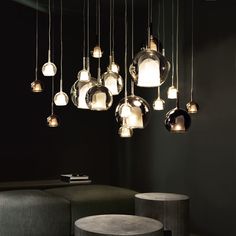 a bunch of lights hanging from the ceiling in a room with black walls and furniture