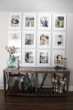 a table with many pictures on it in front of a wall