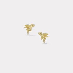 two gold earrings with an animal design on the front and back of each earring