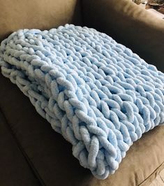 a blue blanket sitting on top of a couch