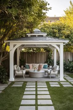 a white gazebo sitting on top of a lush green field