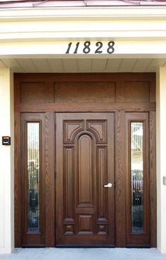 the front door of a house with two doors and numbers on it's side