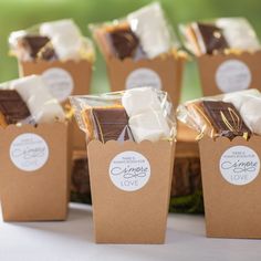 small brown boxes filled with chocolate and marshmallows on top of a table