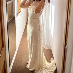 a woman taking a selfie in front of a mirror wearing a wedding dress and veil