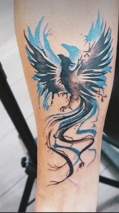 a tattoo on the leg of a person with blue and black birds flying around it