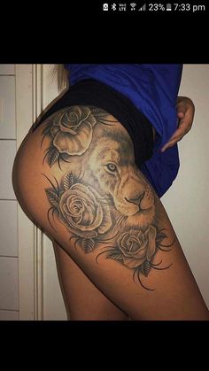 a woman's thigh with roses and a lion on it