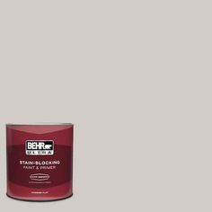 a can of behr ultra stain - blocking paint and primer in grey, on a white background