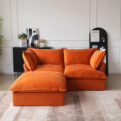 an orange couch sitting on top of a rug