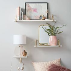 two white shelves with books and plants on them