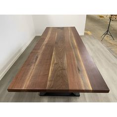 a wooden table sitting on top of a hard wood floor next to a white wall