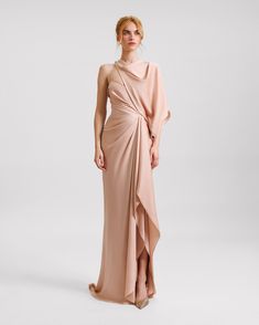 Elegantly draped in satin, this blush-colored evening dress features an asymmetrical neckline and a gracefully ruffled slit on the side. Perfect for formal occasions, its smooth satin fabric ensures a luxurious feel and a flattering silhouette. Drop Waist Gown, Draping Dress, Soft Dramatic, Dramatic Classic, Asymmetrical Neckline, Draped Dress, Wedding Things, Lace Design, Asymmetrical Dress