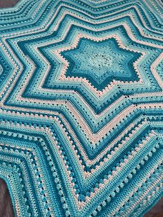 a blue crocheted afghan is on a table