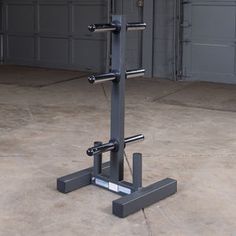 a squat machine in the middle of a parking lot with two garage doors behind it