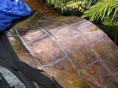 an image of a roof that has been painted gold and silver with blue tarp on it