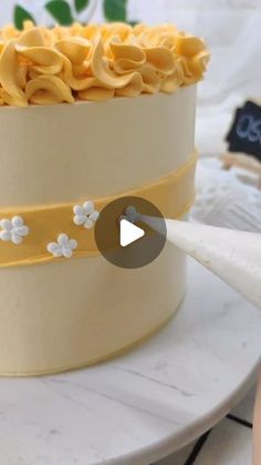 a cake with yellow icing and white flowers on it