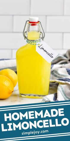 homemade lemoncello in a glass jar on a counter with two lemons and a tea towel